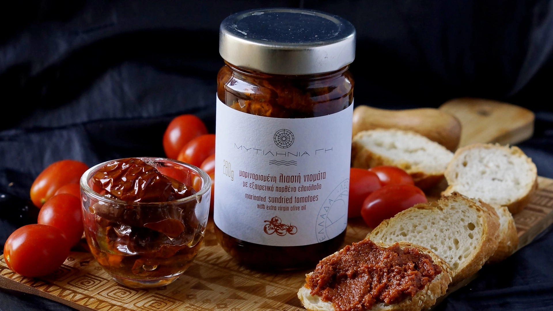 Λιαστή ντομάτα ανάμεσα σε φρέσκα ντοματίνια και άλειμμα λιαστής ντομάτας επάνω σε φέτα ψωμί